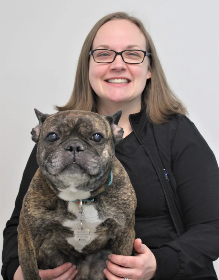Angie of New Haven Pet Hospital posing with a brindle dog